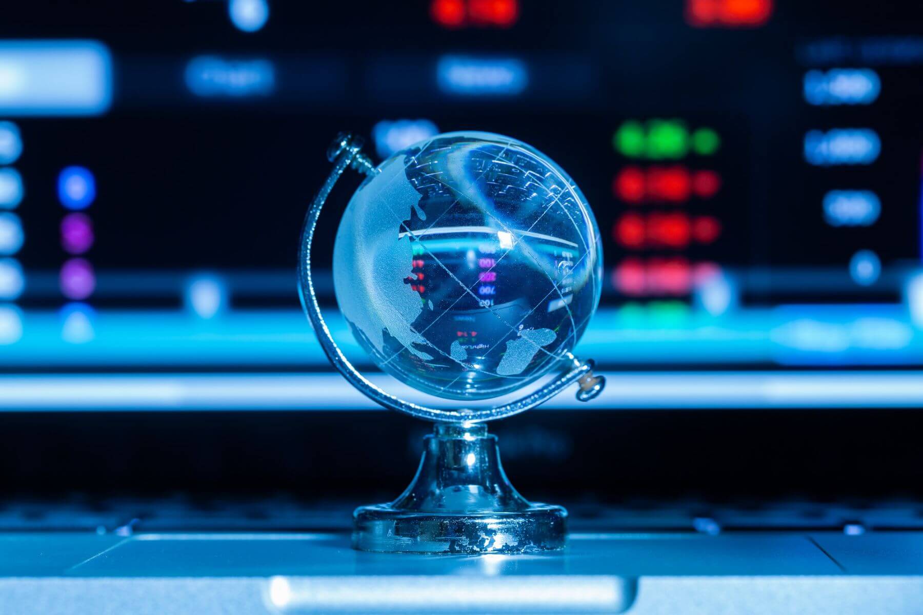kryształowy globus na tle monitora z wyświetlonymi danymi